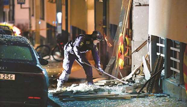 A police officer is seen working on the site where an explosion damaged a residential building in central Stockholm on Sunday.