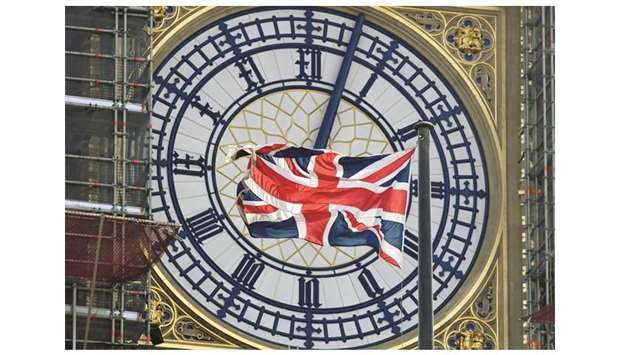 The Union Jack flies in front of the clock face of Big Ben in London.