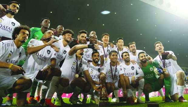 Al Sadd players pose with the Qatar Cup trophy after their 4-0 win over Al Duhail in the final