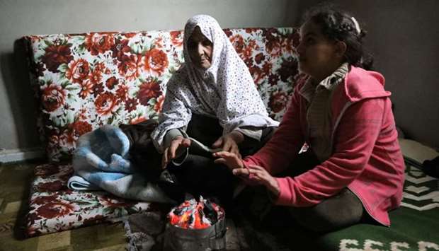 A displaced family warms up their hands at an unfinished apartment in Tripoli, Libya