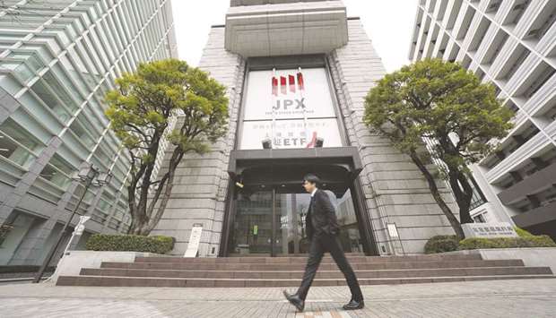A pedestrian walks past the Tokyo Stock Exchange building in Tokyo. The TSE ended 0.5% higher 24,041.26 points yesterday.