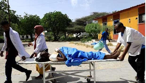 Paramedics at the Madina hospital assist an unidentified man injured in an explosion in Afgoye, as he arrives for medical attention in Mogadishu, Somalia