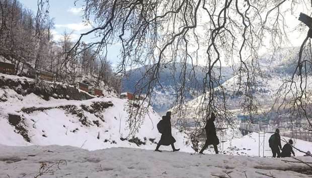 In this picture taken on December 21, 2019, students Bhat Musaddiq Reyaz and Aqeel Mukhtar along with others walk toward the train station in Banihal.
