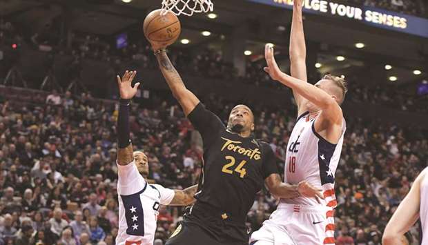 Toronto Raptors guard Norman Powell (centre) goes up for a basket against Washington Wizards centre Anzejs Pasecniks (right) and guard Gary Payton II (20) in the fourth quarter at Scotiabank Arena in Toronto, Canada, on Friday. (USA TODAY Sports)
