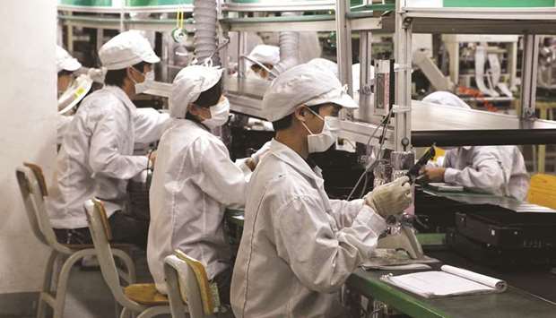 Employees work on the assembly line at Hon Hai Groupu2019s Foxconn plant in Shenzhen, Guangdong province. Hon Hai, the primary listed vehicle for Terry Gouu2019s Foxconn Technology Group, is looking to diversify from its role as the assembler of a swath of the worldu2019s electronics from Macbooks to Sony Playstations.
