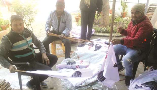 Aam Aadmi Party workers prepare banners and posters to be used during campaigns for the Delhi assembly elections.