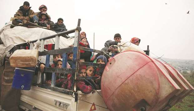 Syrians fleeing towns and villages in the countryside of the northern province of Aleppo drive through the town of Ghazaouia, yesterday, toward safer areas to seek refuge from reported bombing by pro-regime forces.