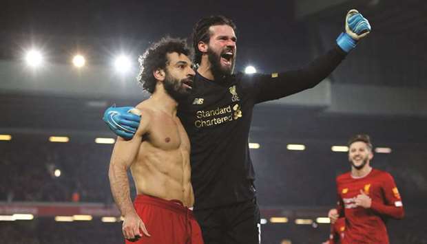 Liverpoolu2019s Mohamed Salah celebrates scoring their second goal against Manchester United with goalkeeper Alisson in Liverpool yesterday.