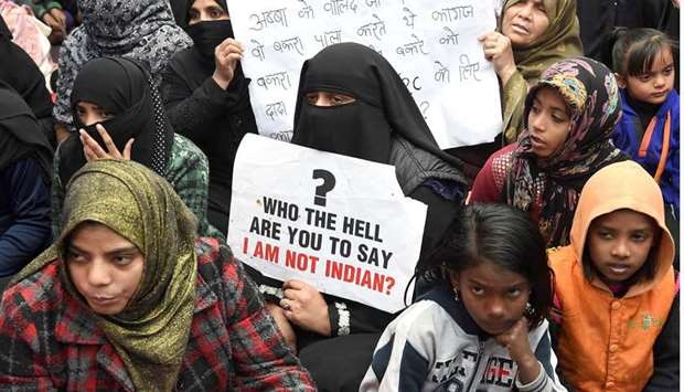 In this file photo taken on January 6, protesters hold placards as they listen to speakers in the Shaheen Bagh, which has been blocked off by demonstrators protesting against the new citizenship law, near the Jamia Millia Islamia university in New Delhi.