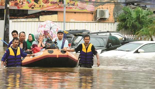 A rescue team evacuates locals on an inflatable boat during a flood after heavy rain in Bekasi, near Jakarta, yesterday.