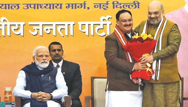 Nadda is congratulated by Home Minister Amit Shah as Prime Minister Narendra Modi looks on at the BJP headquarters in New Delhi yesterday.
