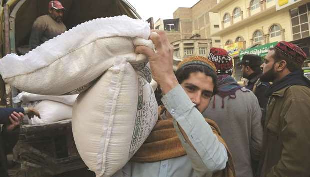 A local resident carries sacks of wheat bought from a vendor in Peshawar. Local media reports said that Pakistanu2019s Economic Co-ordination Committee has approved a proposal to import 300,000 tonnes of wheat to overcome a nationwide shortage that had dramatically raised prices of the food staple.