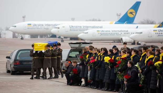 Soldiers carry a coffin containing the remains of one of the eleven Ukrainian victims of the Ukraine International Airlines flight 752 plane disaster during a memorial ceremony at the Boryspil International Airport, outside Kiev, Ukraine Sunday.