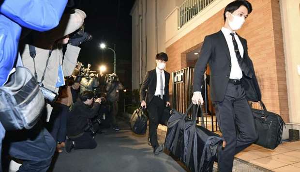 Officials from the Tokyo District Public Prosecutors Office carry bags after raiding the Tokyo residence of former Nissan chairman Carlos Ghosn in Tokyo, Japan.  Kyodo/via REUTERS