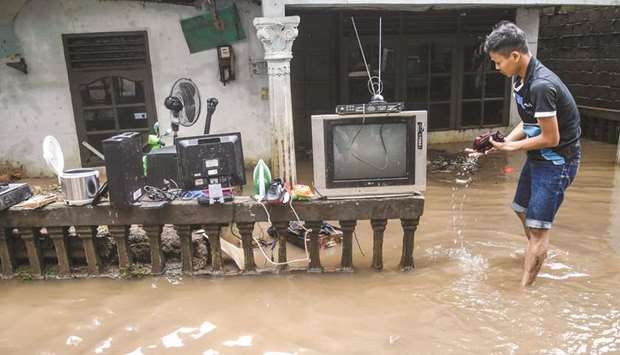 A man collects his stuff after floods hit Jakarta, Indonesia.