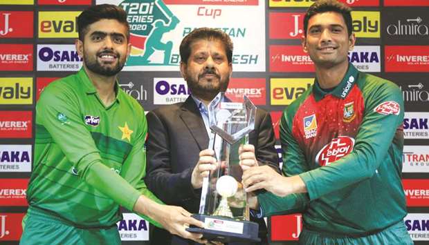 Pakistan captain Babar Azam (left) and Bangladesh captain Mahmudullah (right) pose with T20 series trophy at the Gaddafi Stadium in Lahore yesterday. (Reuters)