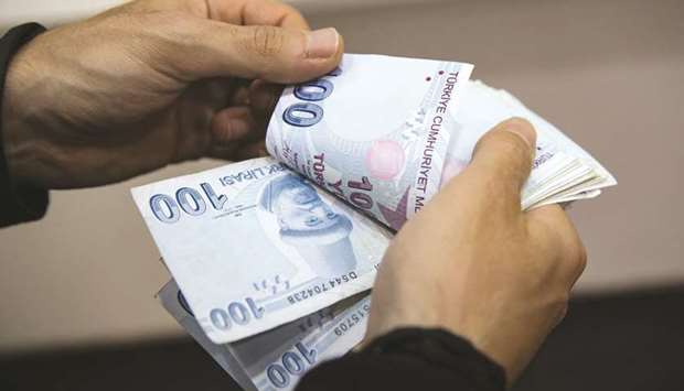 A customer counts Turkish one-hundred lira banknotes inside a foreign currency exchange bureau in the Beyoglu district of Istanbul (file). The nationu2019s six largest lenders will report their first quarterly profit gains after three straight quarters of declines, according to the median estimate of 15 analysts in a Bloomberg survey.