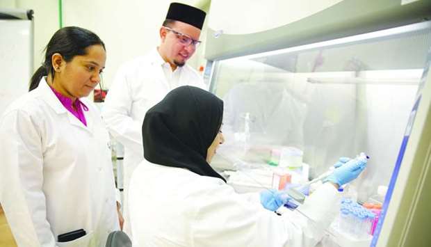 Anwarul Hasan, an assistant professor and the lead principal investigator of the project at Qatar University, is seen with two team members in a lab.