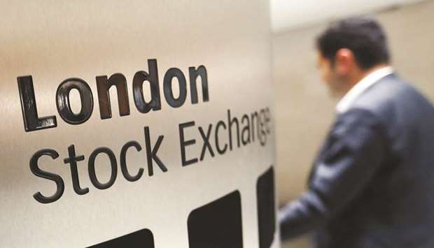 A visitor passes a sign inside the London Stock Exchange Group headquarters. The FTSE 100 ended the session 1.1% higher at 7,585.98 points yesterday.