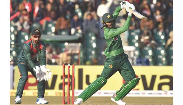 Shoaib Malik (right) plays a shot as Bangladeshu2019s wicketkeeper Liton Das looks on during the first T20 at Gaddafi Cricket Stadium in Lahore yesterday. (AFP)