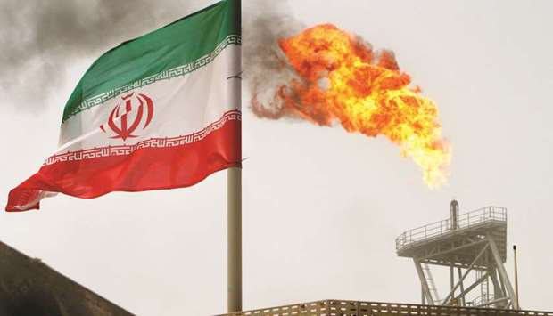 A gas flare on an oil production platform in the Soroush oil fields is seen alongside an Iranian flag in the Gulf (file). The US sanctioned four companies that it says have traded hundreds of millions of dollars worth of Iranian petroleum and petrochemicals in its latest effort to clamp down on the Islamic Republicu2019s revenue sources.