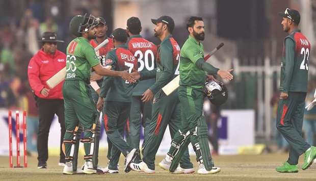 Pakistanu2019s cricket team captain Babar Azam and Mohamed Hafeez (second right) greet Bangladesh players after winning the second T20 international at the Gaddafi Cricket Stadium in Lahore yesterday. (AFP)