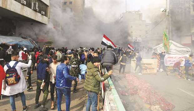 The smoke from burning tents is seen, as Iraqi security forces raided Baghdadu2019s main protest site at Tahrir Square, during ongoing anti-government protests in Baghdad, yesterday.