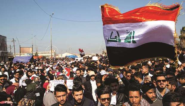 Iraqi demonstrators wave the national flag during an anti-government rally in the southern city of Basra, yesterday.
