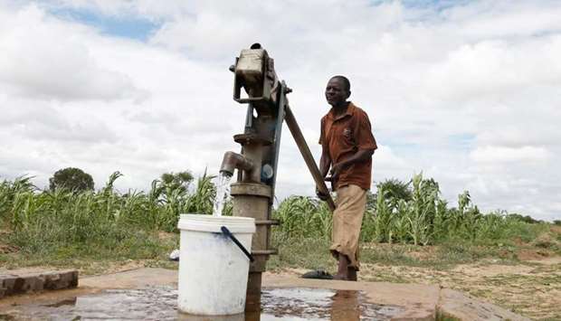 A man pumps water from a borehole to feed his wilting crops during prolonged drought in Bulawayo