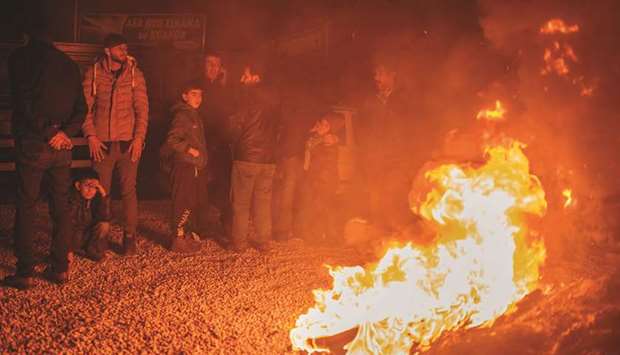 People spend the night in a park in Elazig, eastern Turkey, near a huge fire.