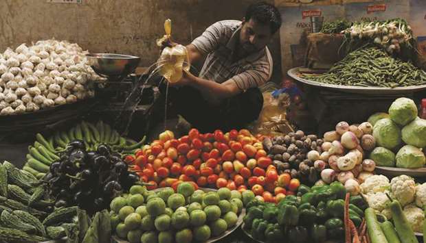 A vegetable seller sprinkles water to keep them fresh and shine at a makeshift stall along a market in Karachi. The prices of essential seasonal fruits and vegetables in Pakistan have increased despite fresh harvest as the government failed to rein in rising inflation.