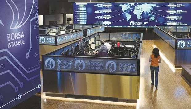 Employees work in their booths at the Borsa Istanbul stock exchange in Istanbul (file). The rally in Turkish equities that has carried the benchmark index to record highs this year was largely driven by gains in shares in small and medium-cap companies that started in the second half of 2019.
