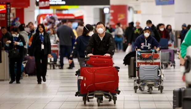 Travellers are seen wearing masks at the international arrivals area