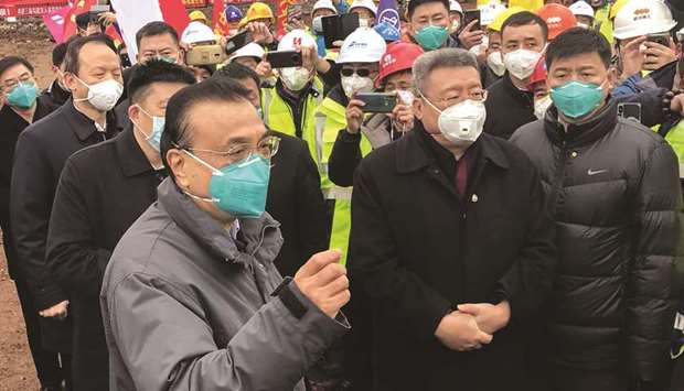 Chinau2019s Premier Li Keqiang (left) speaks as he visits a construction site of a new hospital being built to treat patients of a deadly virus outbreak in Wuhan in Chinau2019s central Hubei province yesterday.