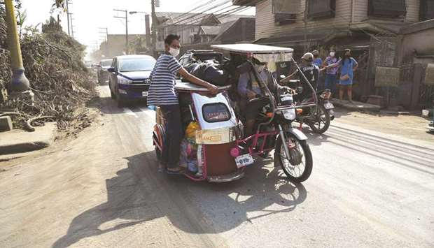 Residents return home to Talisay, Batangas province, yesterday, two weeks after the nearby Taal volcano erupted.