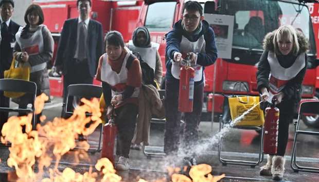 Participants attend a ,fire extinguisher training, exercise during a ,disaster preparedness drill, organised by the Tokyo Metropolitan Government at the Musashino Forest Sports Plaza, the venue for the badminton and the modern pentathlon events at the upcoming Tokyo 2020 Olympics