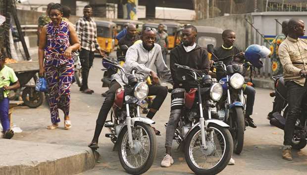 Motorcycle taxi drivers sit on their bikes, popularly called u201cOkadau201d, in Obalende, Lagos Island, Nigeria.