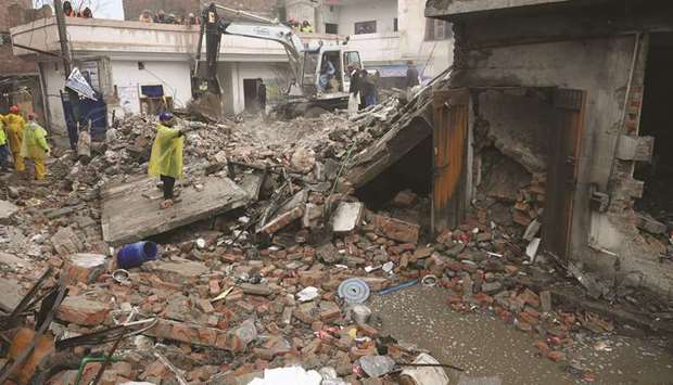 Rescuers search for victims in the debris of the collapsed factory in Lahore.