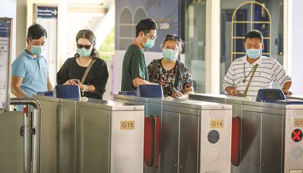 Chinese tourists wearing protective face masks leave the city commuter train station in Bangkok yesterday.