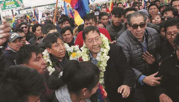 Boliviau2019s former economy minister and Movement to Socialismu2019s (MAS) presidential candidate Luis Arce Catacora greets supporters after arrival at an international airport in El Alto, Bolivia, yesterday.