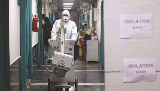 A medical staff member wearing protective clothing works at an isolation ward in a New Delhi hospital yesterday. Three patients are under observation in the hospital after returning from different parts of China.