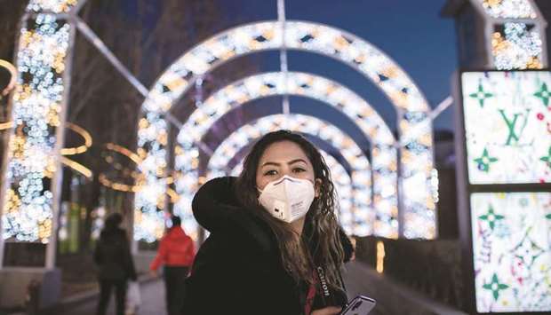 A woman wearing protective face mask outside of a shopping mall in Beijing. Foreign governments have airlifted their citizens out of Wuhan, the epicentre of the outbreak, and airlines have suspended flights to and from China.