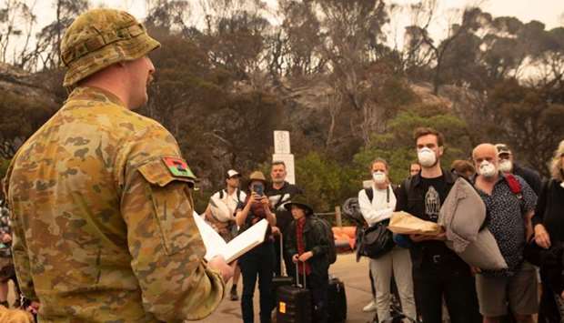 Lieutenant Declan Michell (L) briefing people before being evacuated from Mallacoota, Victoria state, during bushfire relief efforts. AFP / ROYAL AUSTRALIAN NAVYHelen FRANK