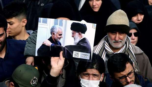 A demonstrator holds a picture of Supreme Leader Ayatollah Ali Khamenei with Iranian Major-General Qassem Soleimani, during protest against the assassination of Soleimani, head of the elite Quds Force, and Iraqi militia commander Abu Mahdi al-Muhandis who were killed in an air strike in Baghdad airport, in Tehran