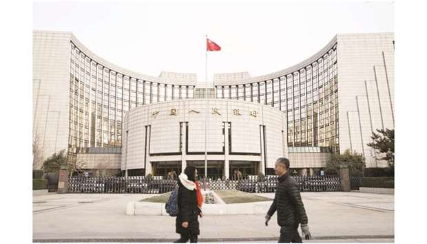 Pedestrians walk past the Peopleu2019s Bank of China headquarters in Beijing. The PBoC, with about $5.42tn of assets at the end of 2018, is the worldu2019s biggest central bank by assets, a senior central banker said.