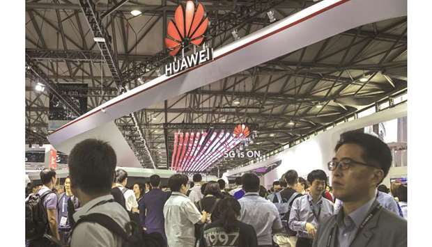 Attendees walk past the Huawei Technologie booth at the MWC Shanghai exhibition (file). Chinau2019s biggest technology company recorded an 18% rise in sales to 850bn yuan ($120bn) this year, down from about 23% in the first half and missing its own internal targets.