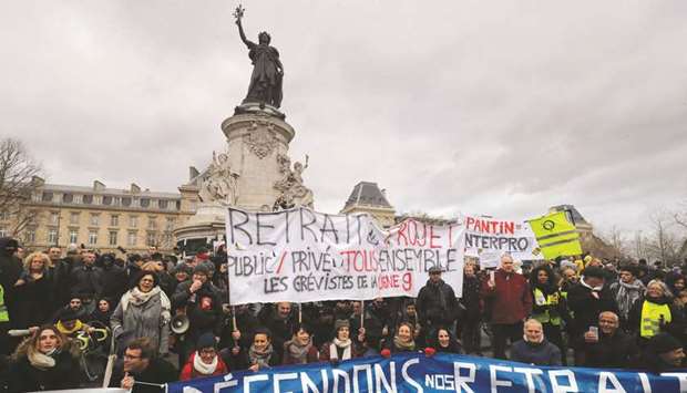 Protesters hold a banner reading u2018Letu2019s protect our pension, block Macronu2019 during a demonstration on the Place de la Republique in Paris, called by French national trade union General Confederation of Labour (CGT) against pension reform.