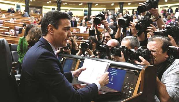Media representatives take pictures of Sanchez before the investiture debate at the parliament in Madrid.
