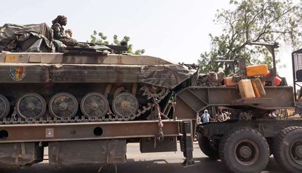 A soldier of the Chad Army sits on top of a tank that is transported on a truck in N'Djamena Friday, upon their return after a months-long mission fighting Boko Haram in neighbouring Nigeria