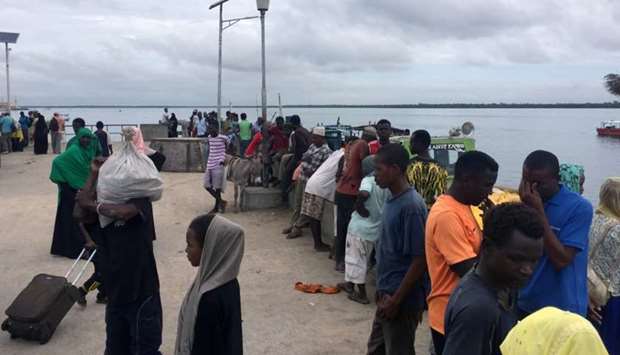 Travellers are seen gathered at the Lamu jetty following an attack by Somalia's al Shabaab militants on a military base in Manda, Lamu, Kenya